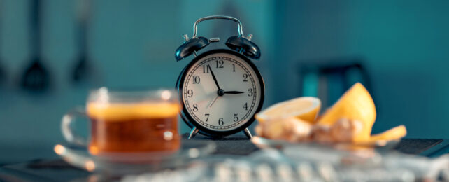 clock with coffee and oranges nearby