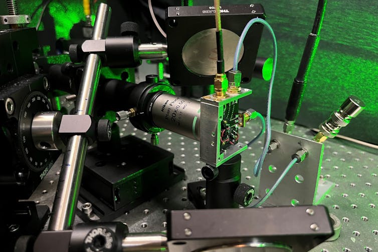 a metal apparatus with green laser light in the background