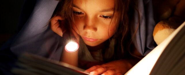 Girl Reads Book By Torch