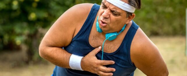 A man coughing and clutching his chest