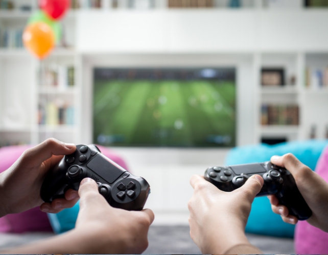 Two people's hands holding game controllers 