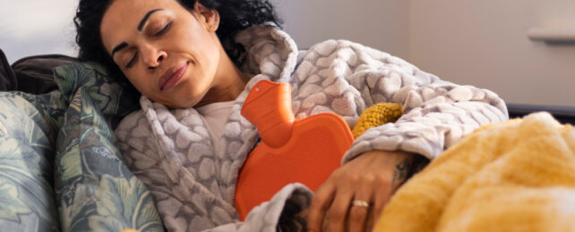 woman holding a hot water bottle for warmth