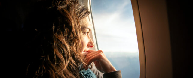 woman staring out the window on a plane