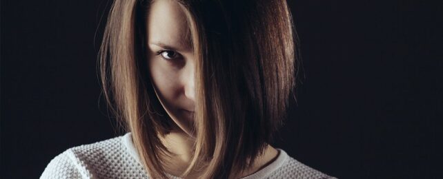 woman looking up cunningly from behind hair